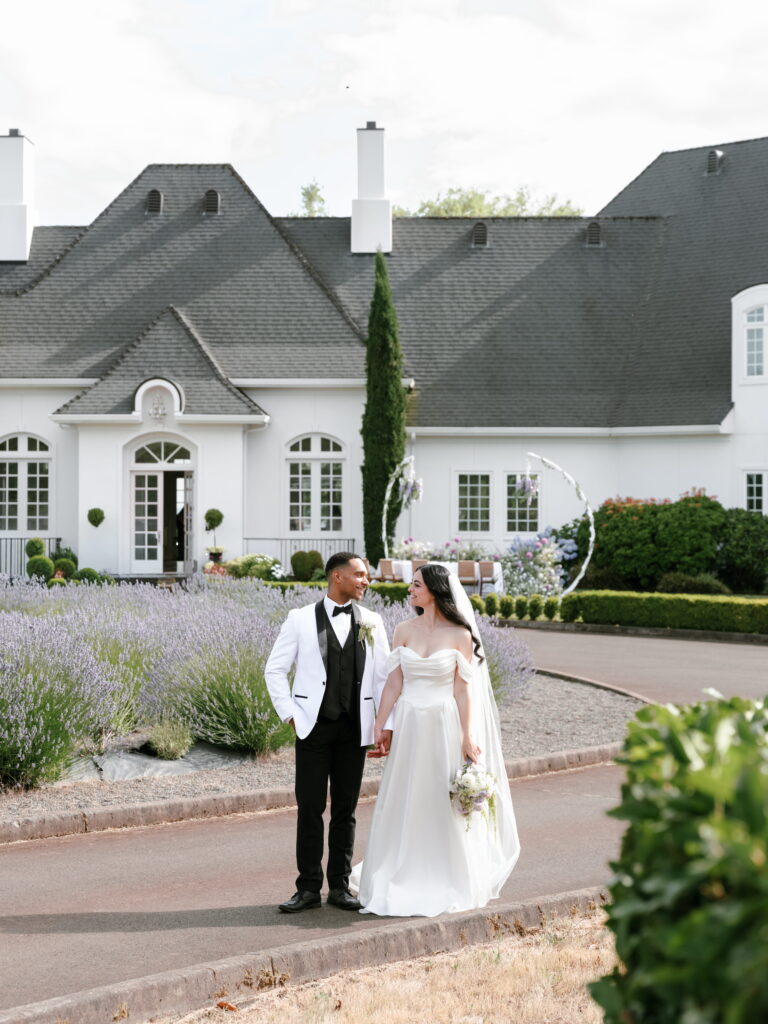 Bride and groom surrounded by blooming lavender in Oregon at wedding venue